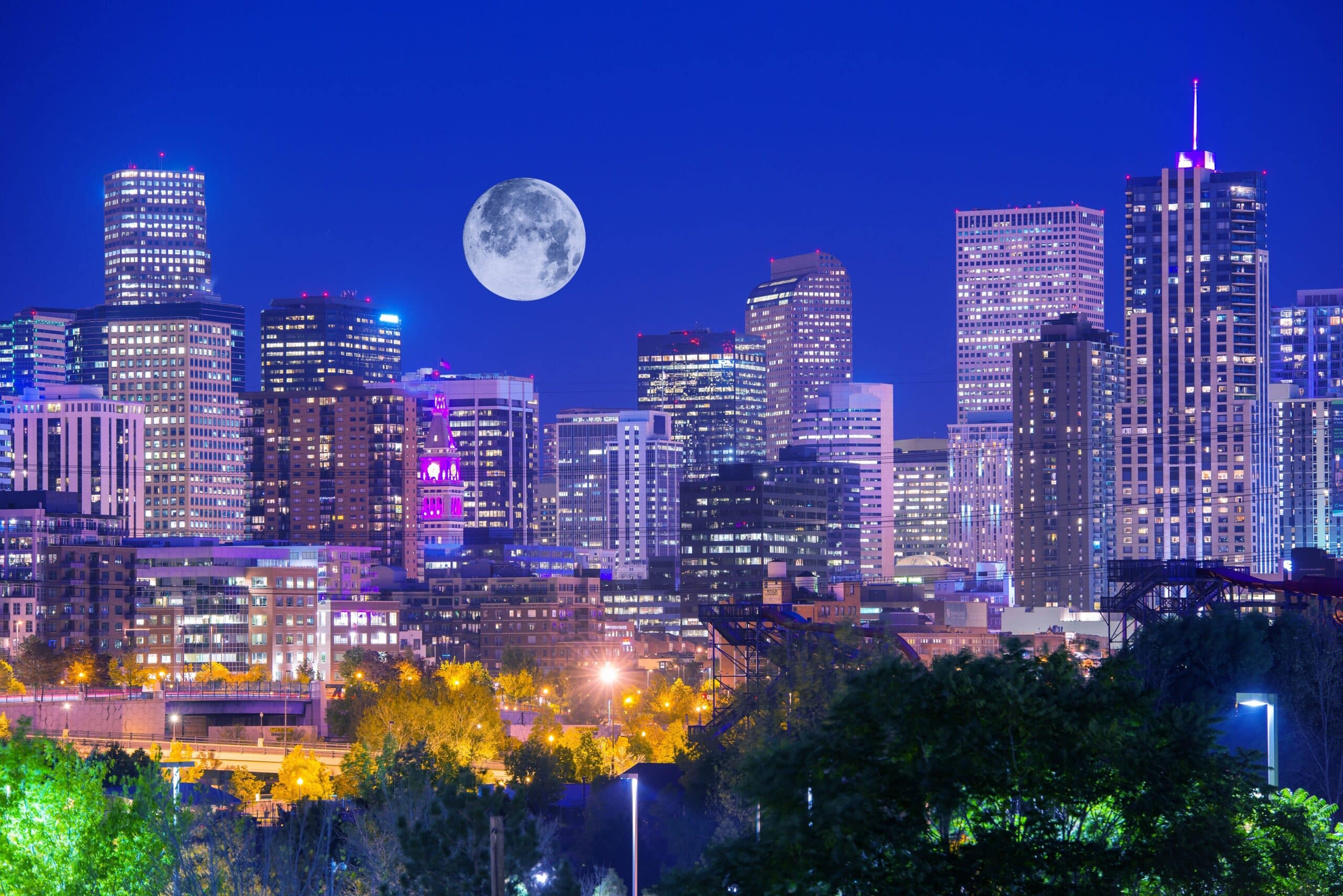 Denver Colorado at Night. Denver Downtown Skyline and the Full Moon on Clear Sky.